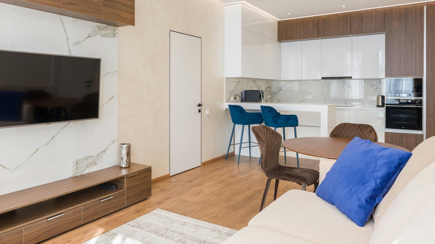 Salón moderno con cocina americana en un alojamiento turístico gestionado de forma profesional.